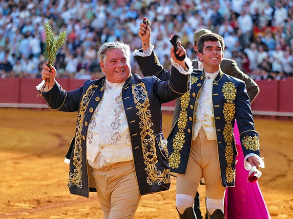 Padre e hijo pasean un trofeo