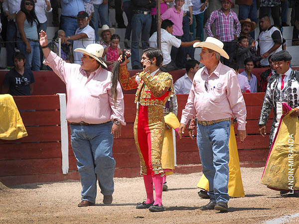 Ganaderos y matador trofeo en mano